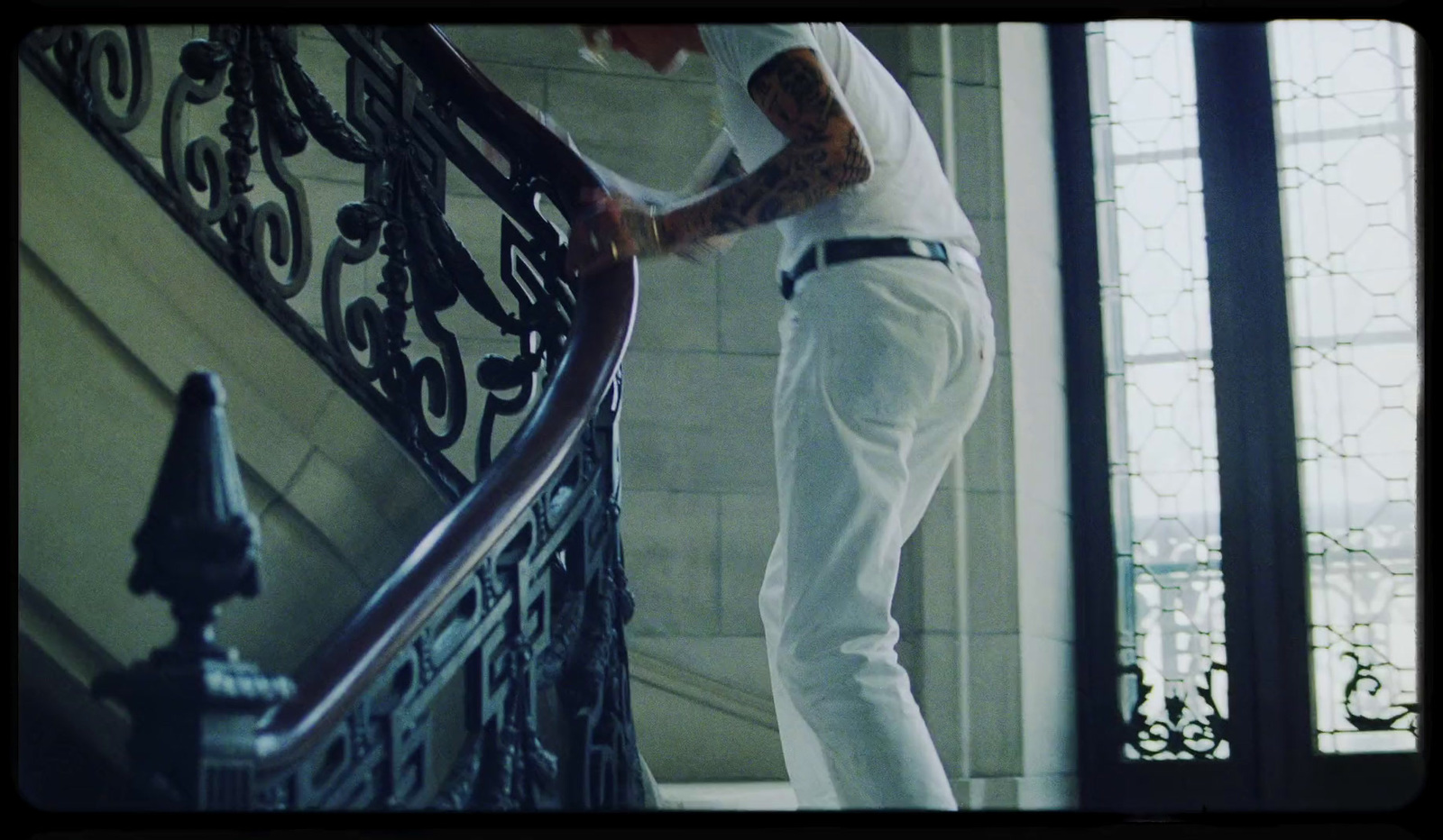 a man standing on a stair case next to a window