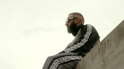 a man sitting on top of a cement wall