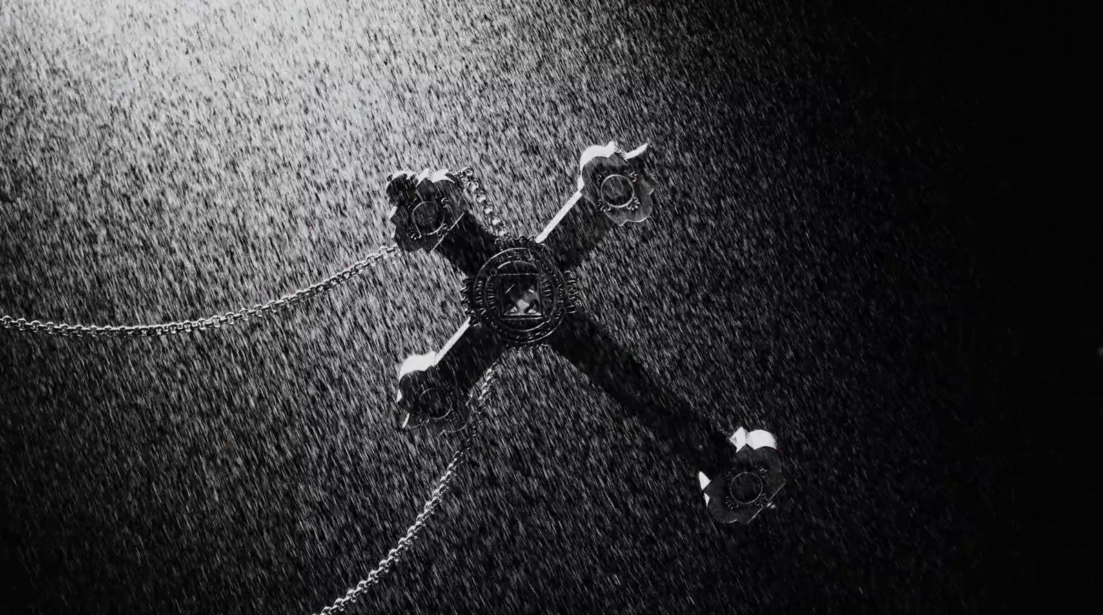 a black and white photo of a cross in the rain