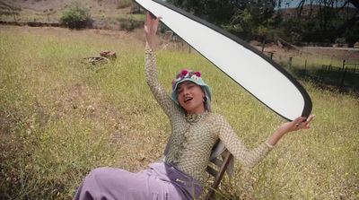 a woman sitting in a chair holding a mirror