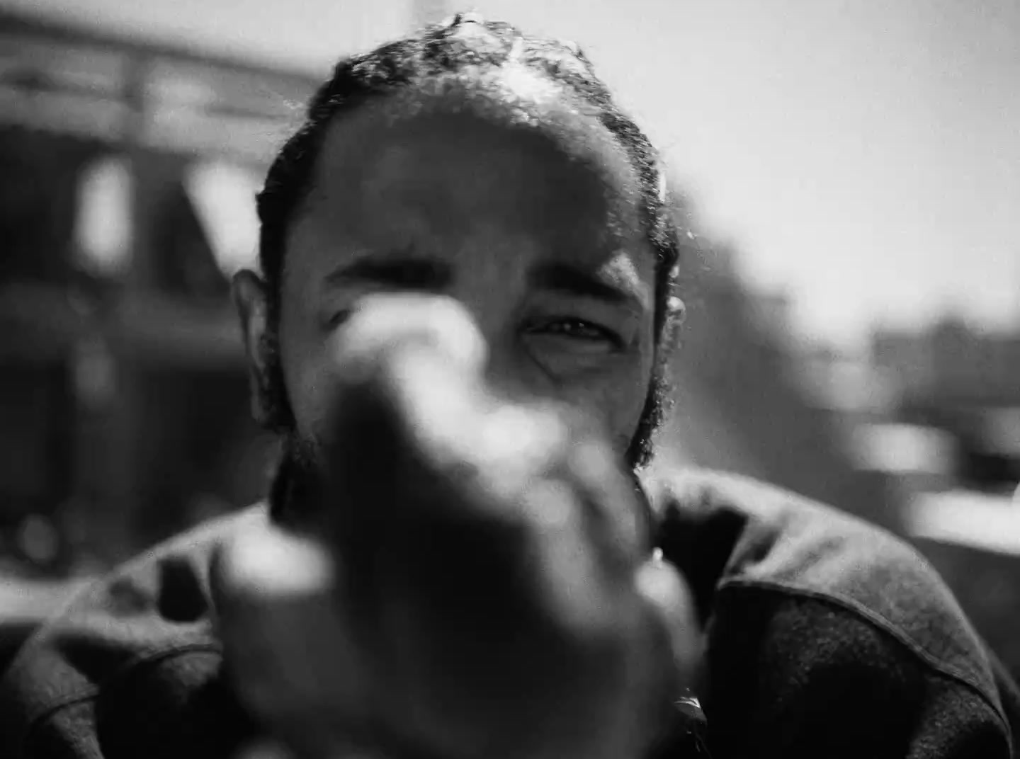 a black and white photo of a man pointing at the camera