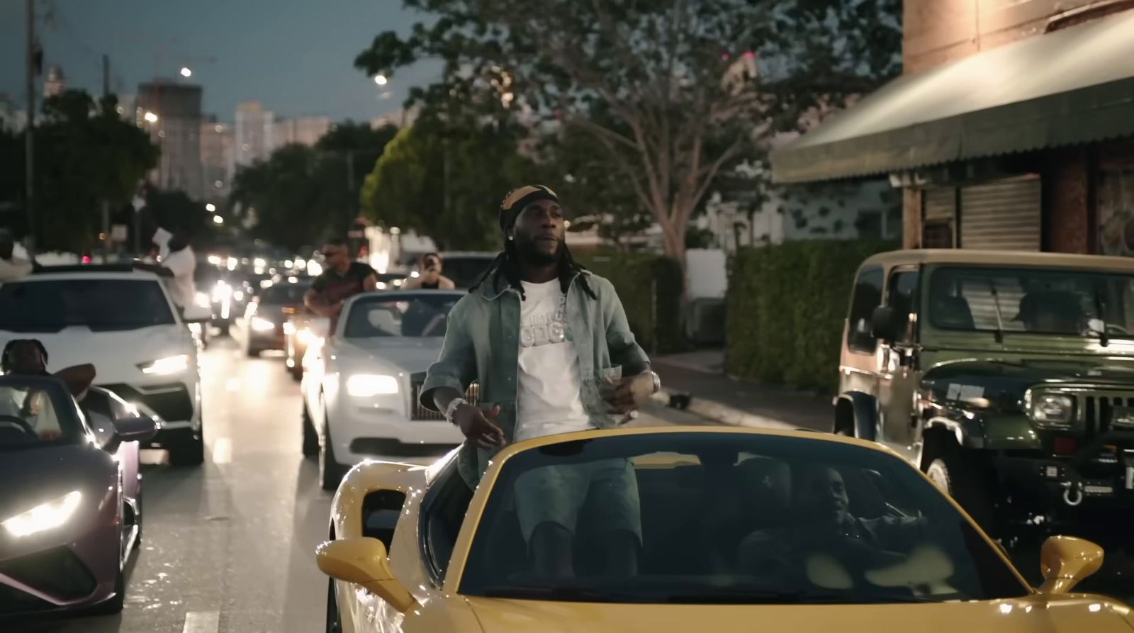 a man standing next to a yellow sports car