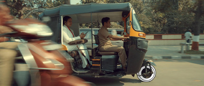 a man driving a motor scooter down a street