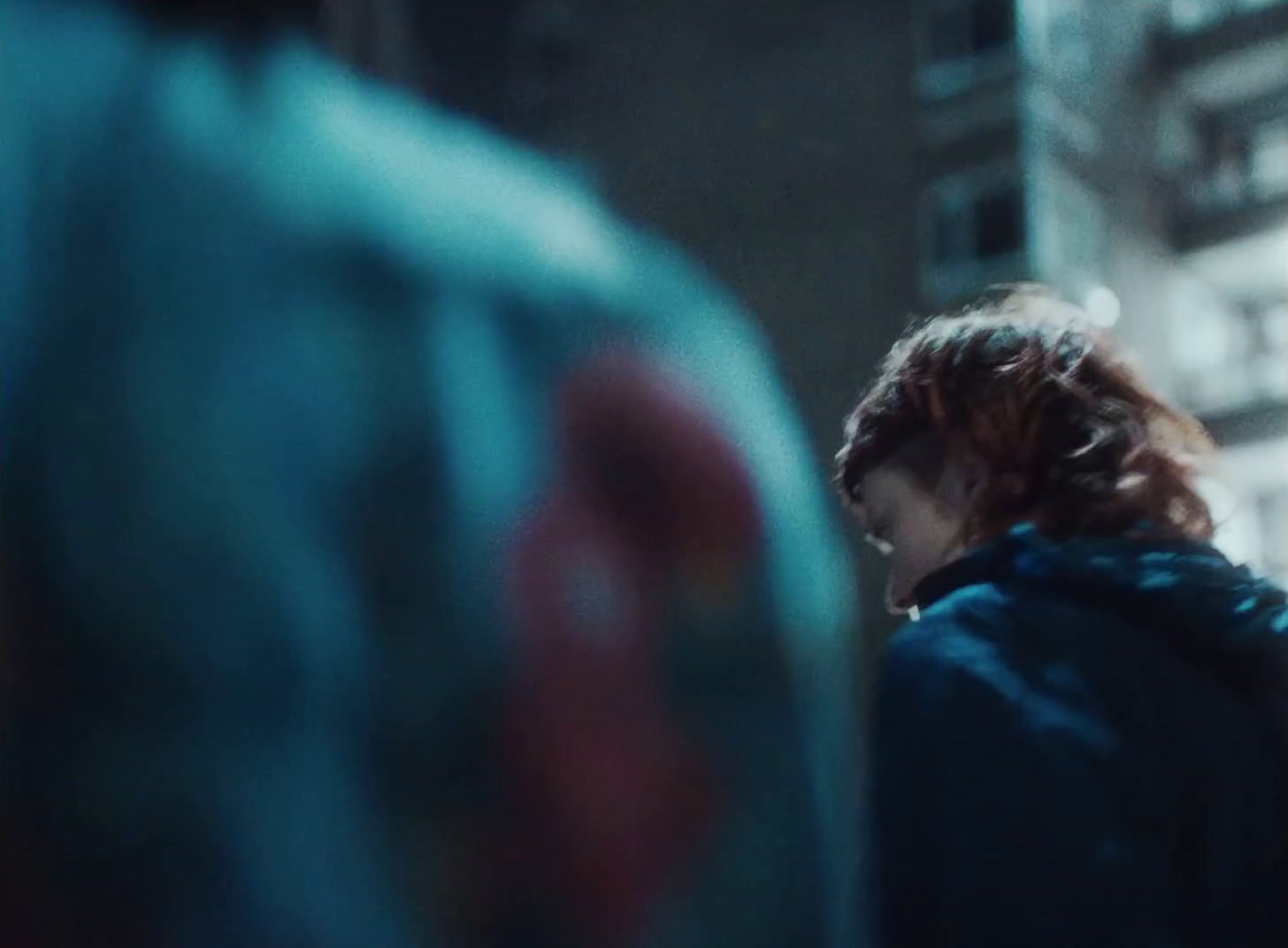 a woman with red hair standing in front of a building