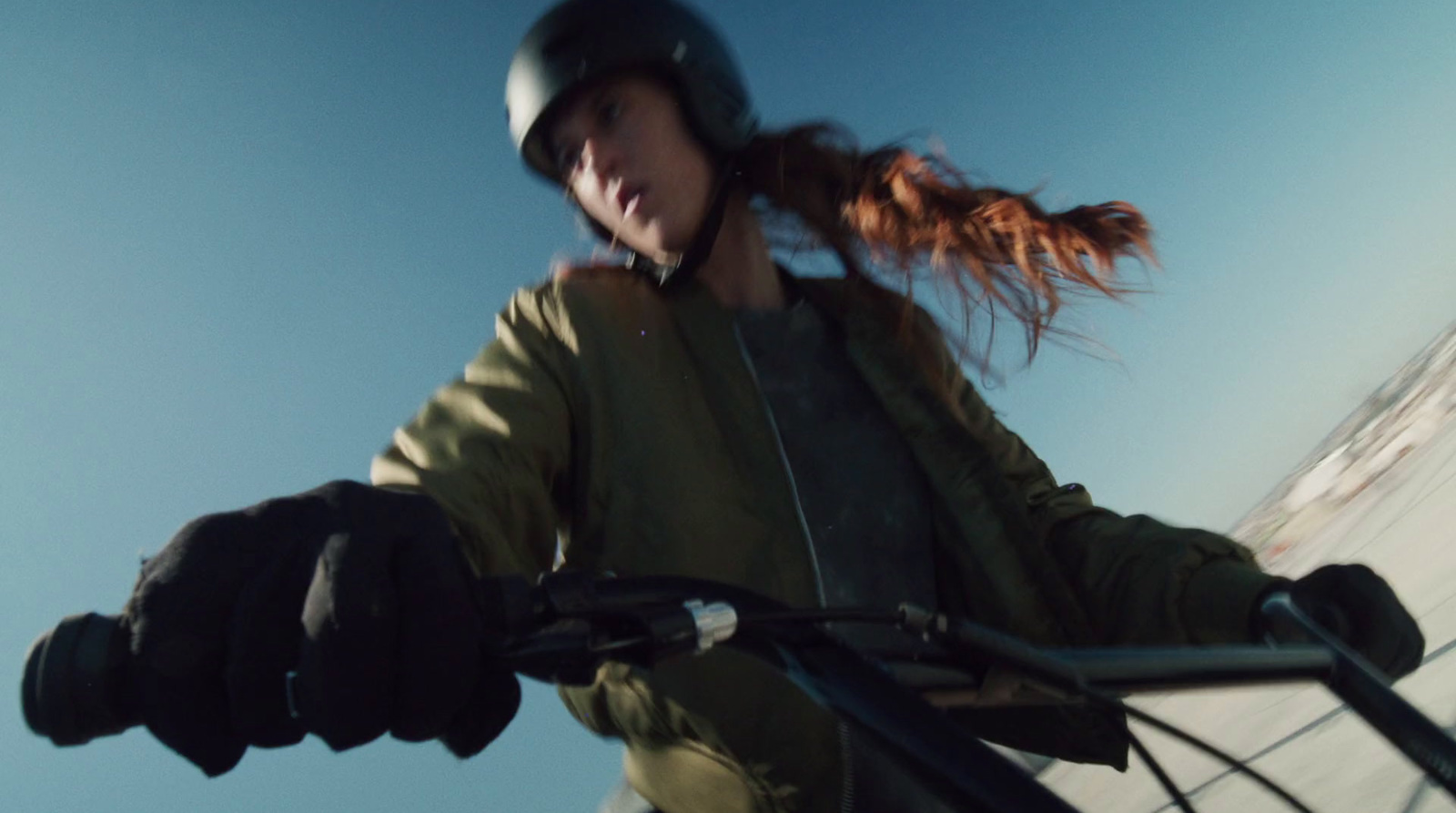 a woman riding a bike with a helmet on