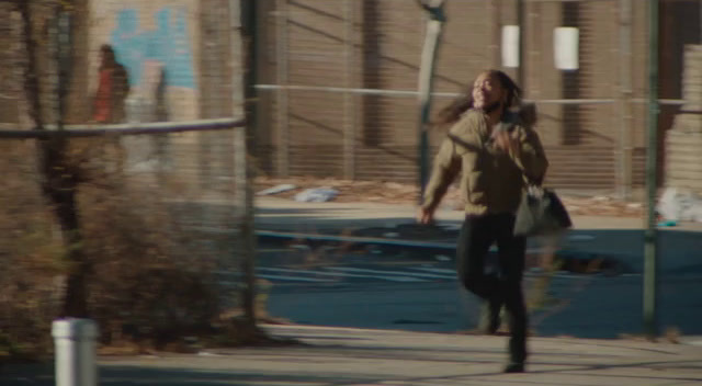 a woman walking down a sidewalk talking on a cell phone