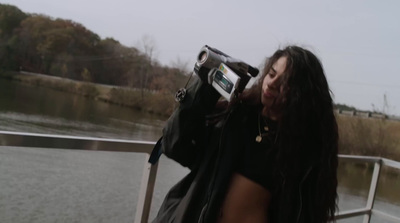 a woman taking a picture of a body of water