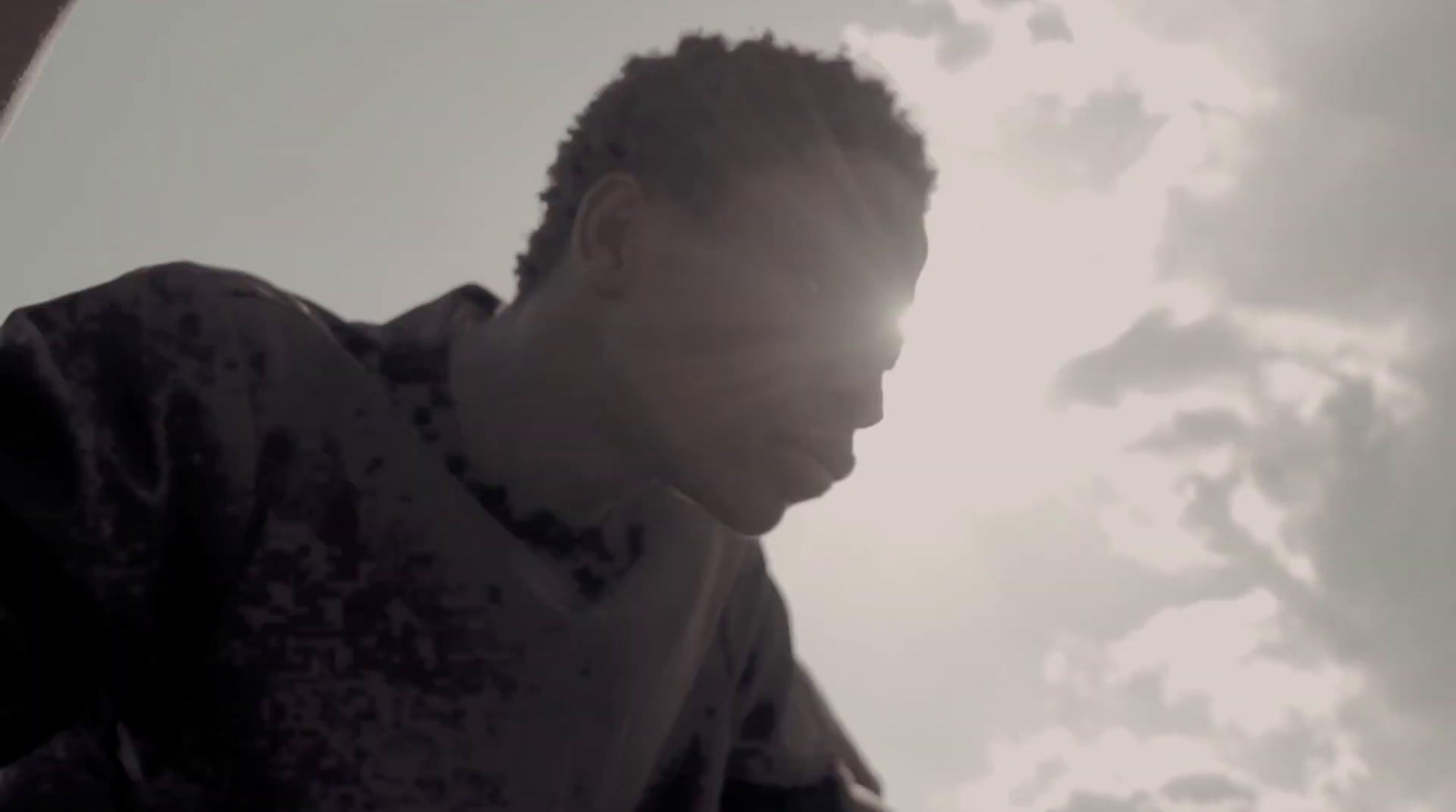 a man standing in front of a cloudy sky