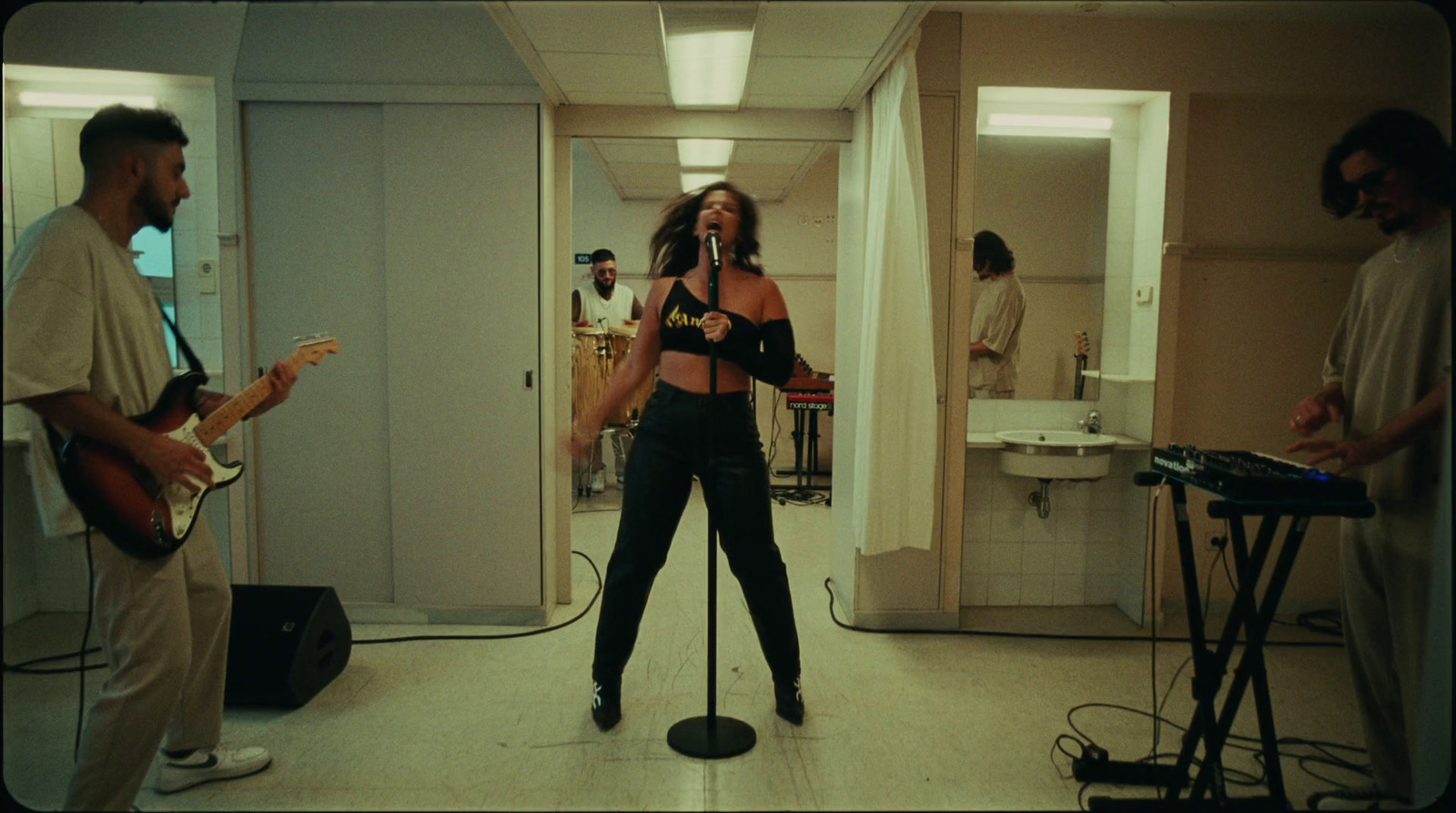 a woman singing into a microphone in a room