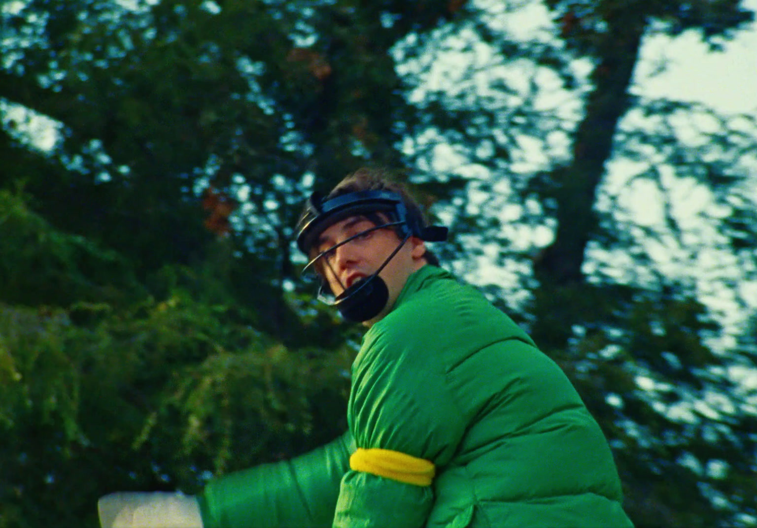 a man in a green outfit talking on a cell phone