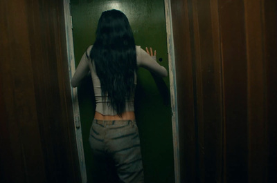 a woman standing in a doorway with her back to the camera