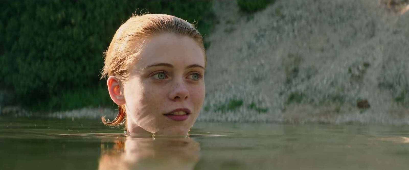 a woman in a pool of water looking at the camera