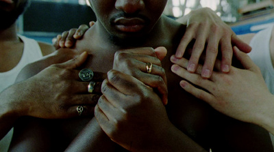 a close up of a shirtless man holding his hands together