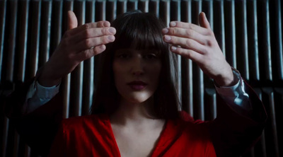 a woman in a red dress holding her hands up to her head