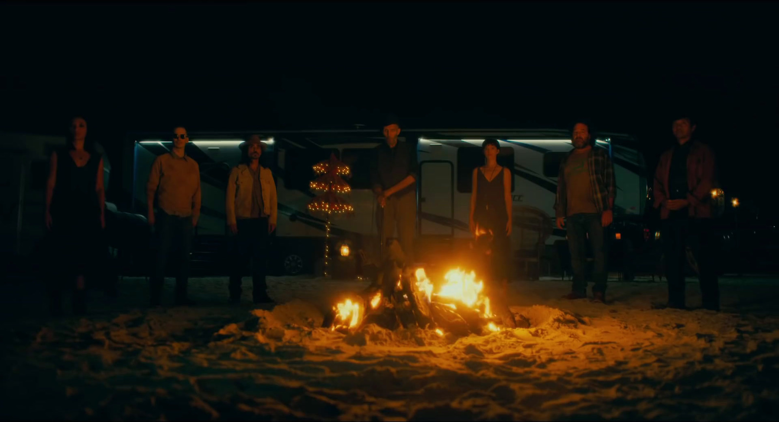 a group of people standing around a fire