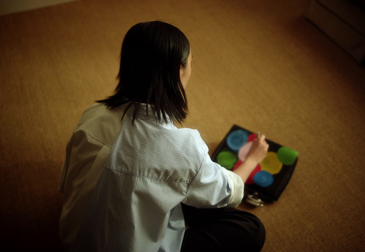 a woman sitting on the floor playing with a toy