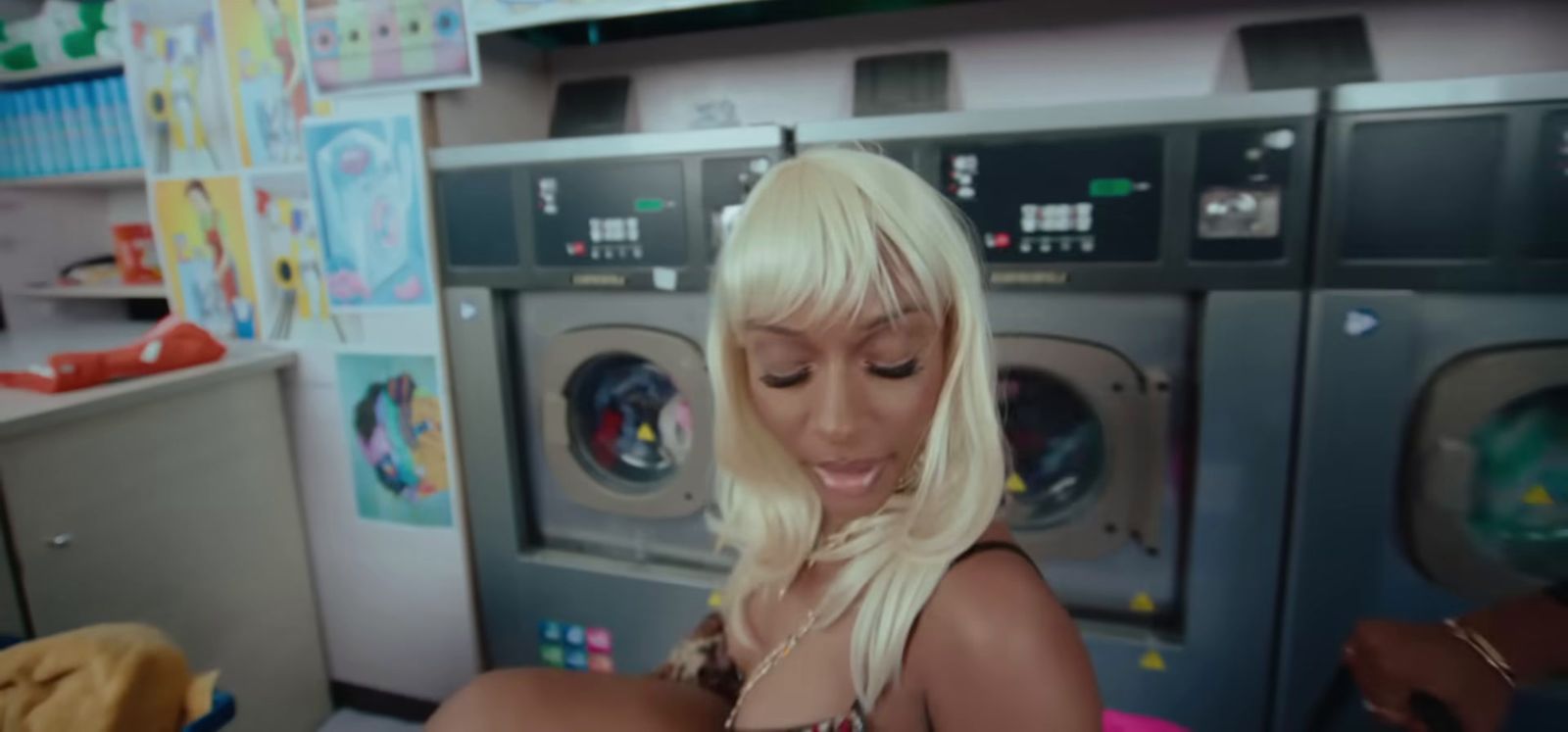 a blonde woman sitting in front of a stack of washers