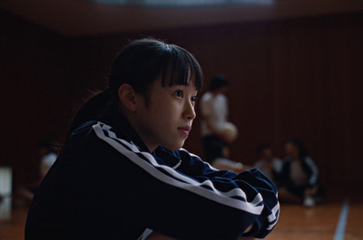 a young girl holding a tennis racquet on top of a hard wood floor