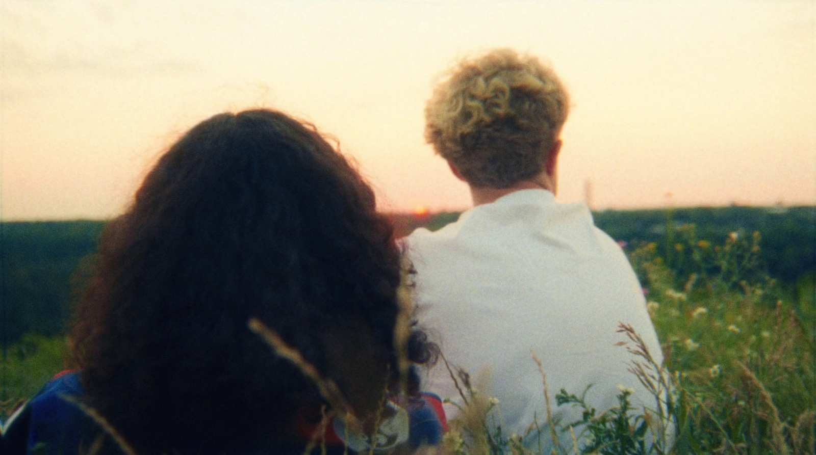 a couple of people sitting in a field