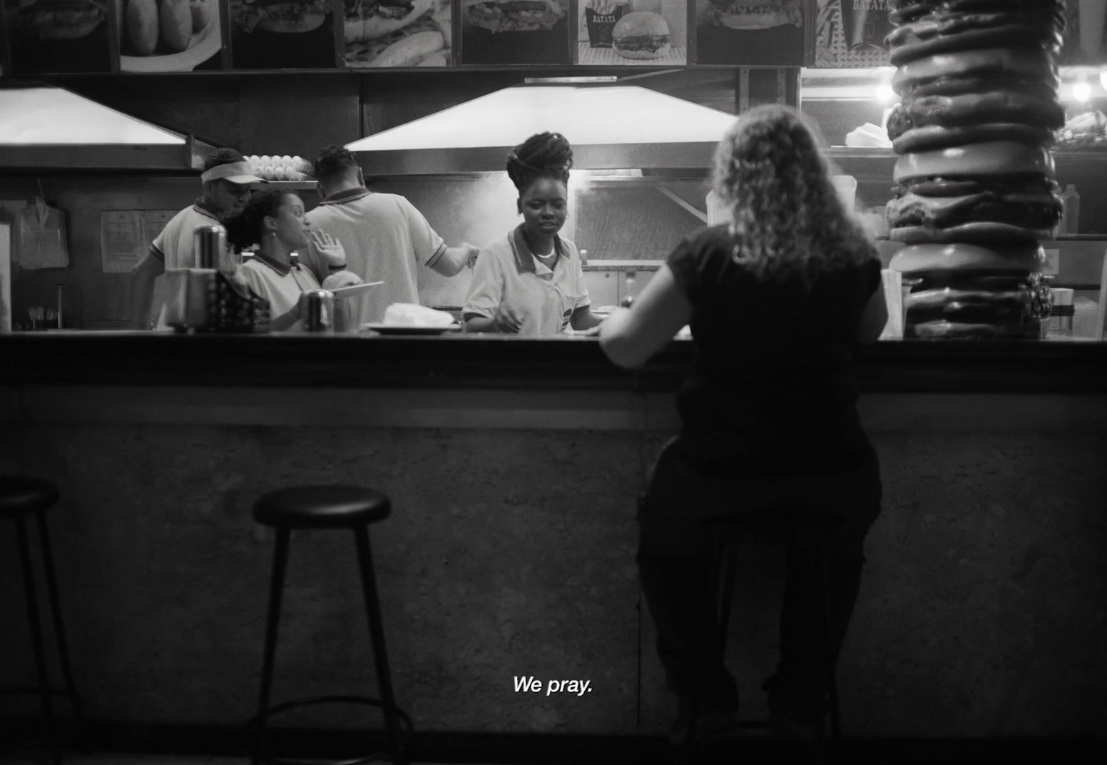 a group of people standing at a counter in a restaurant