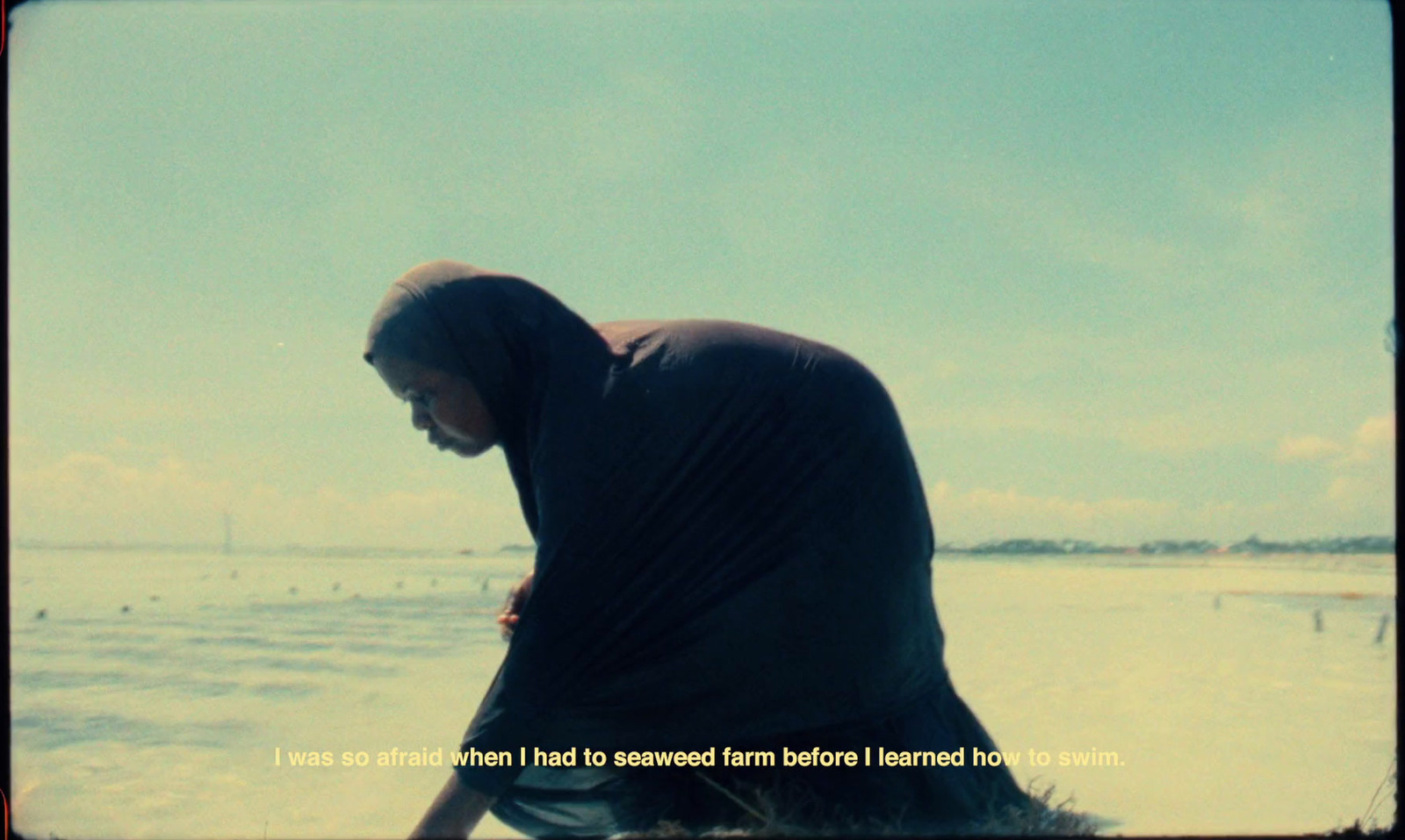 a man sitting on a beach next to the ocean