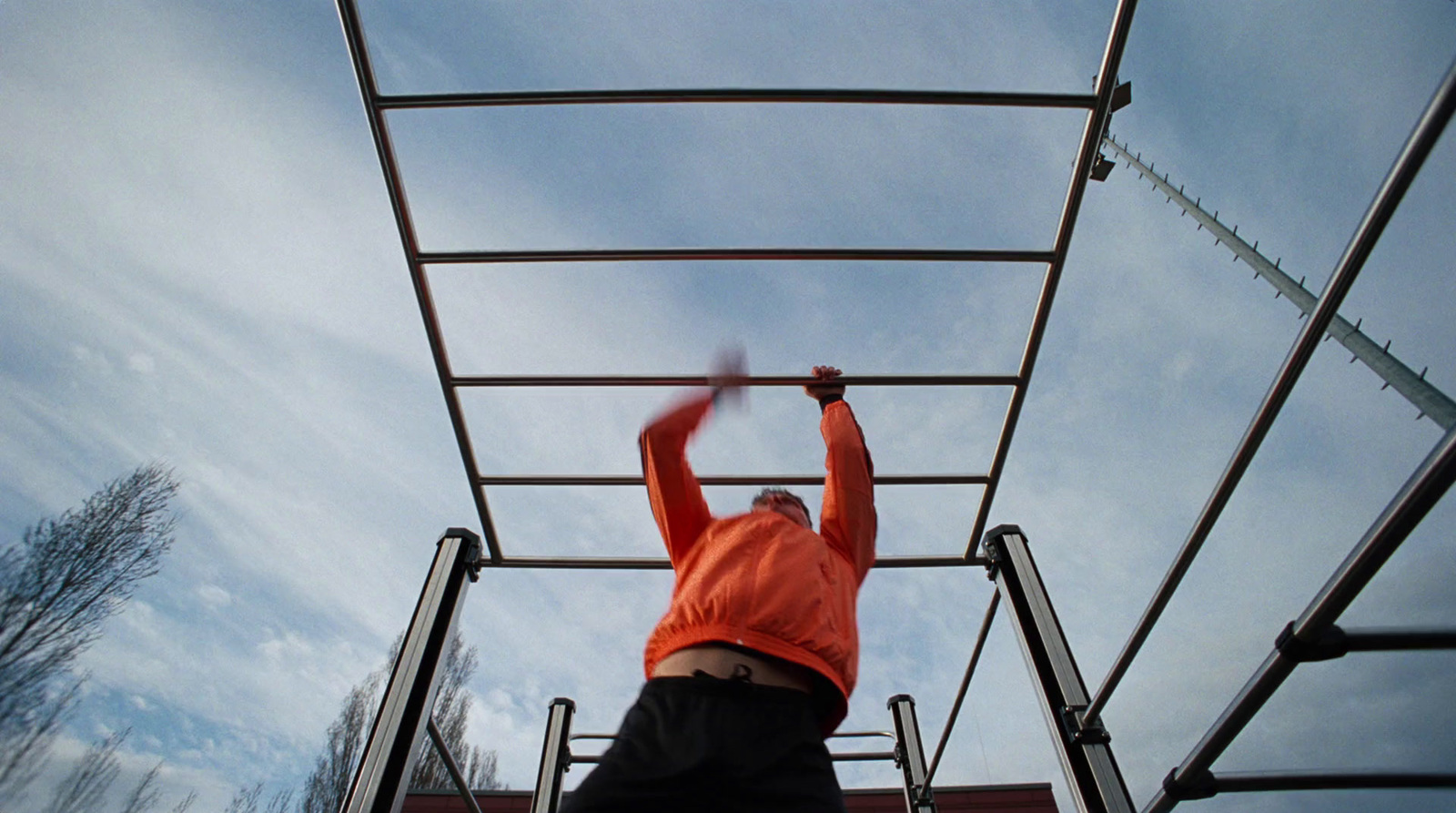 a man in an orange shirt is on a ladder