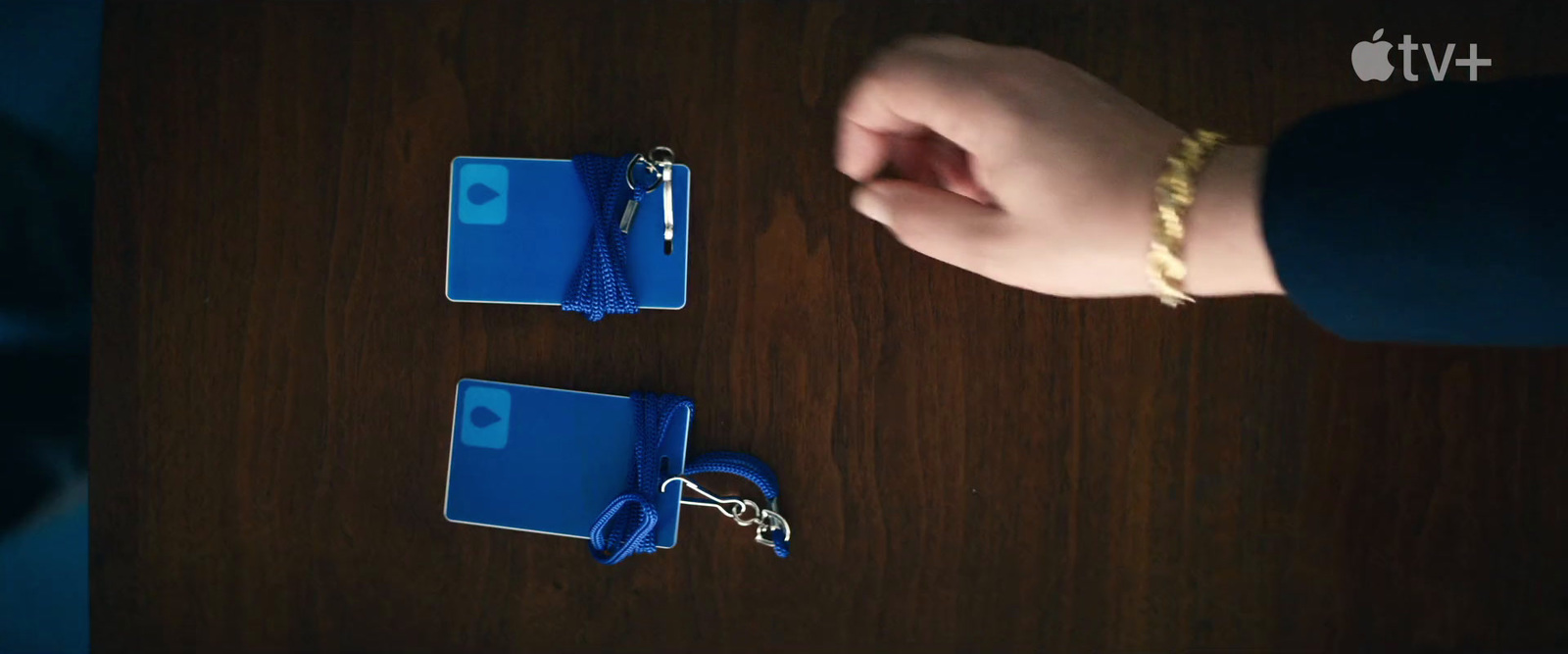 a person is holding a blue folder and a key chain