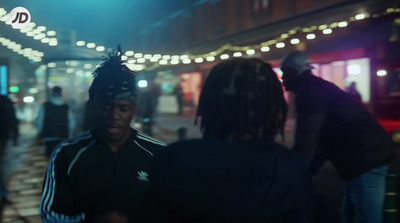 a group of people walking down a street at night