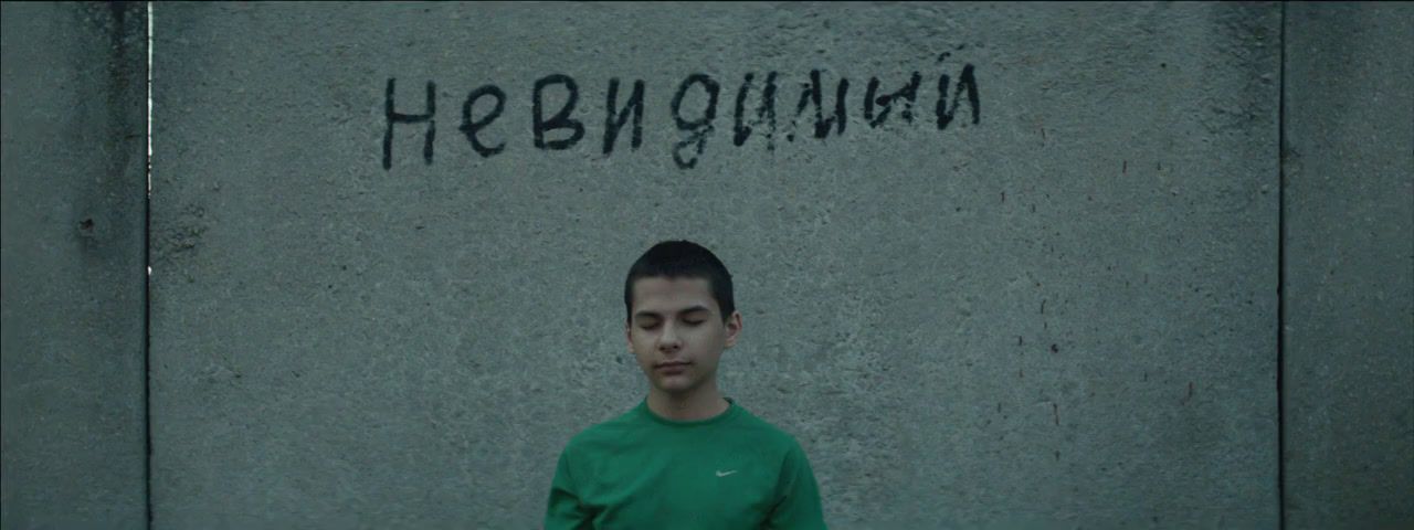 a man standing in front of a wall with graffiti on it