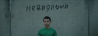 a man standing in front of a wall with graffiti on it