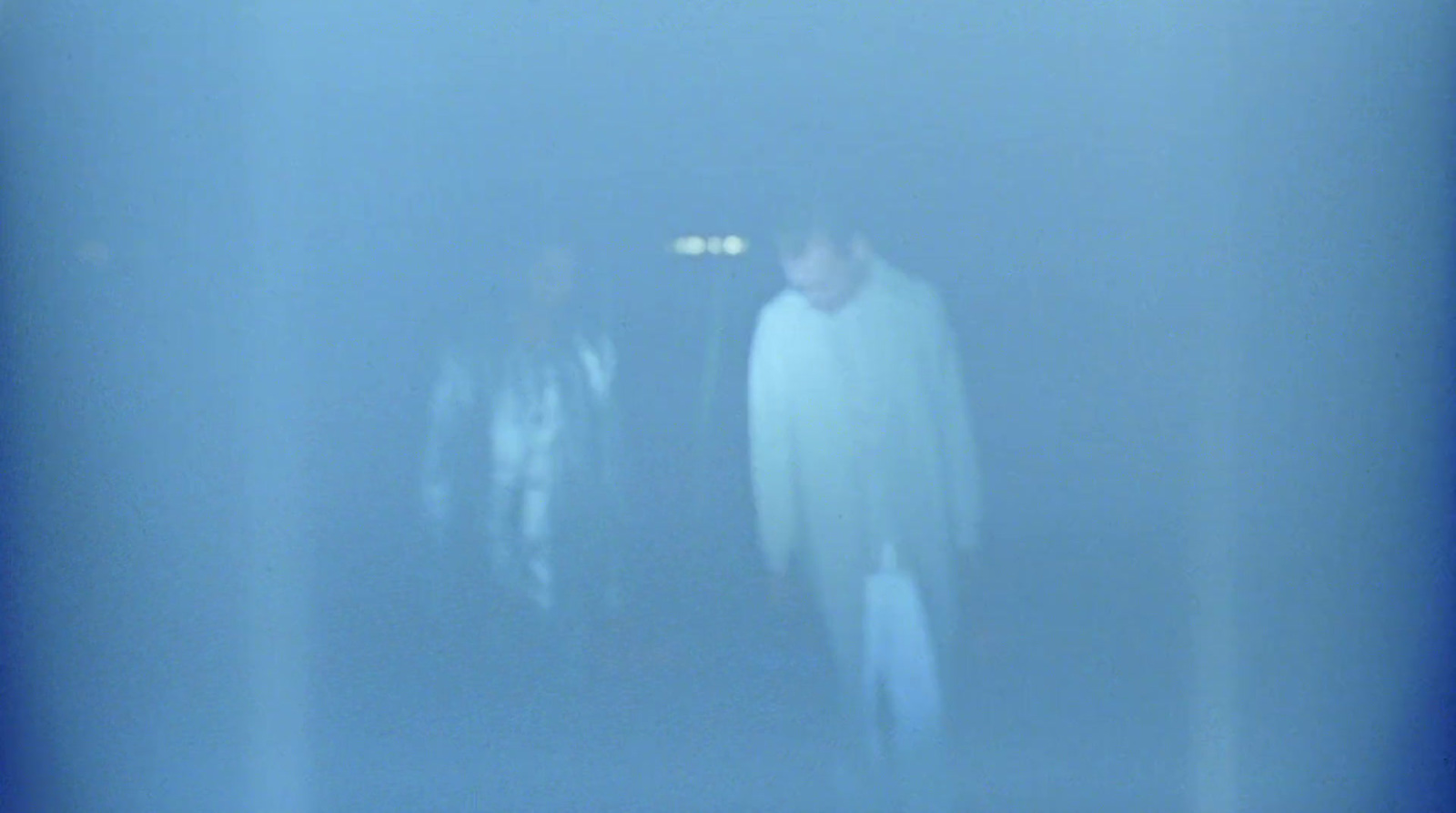 a blurry photo of two people standing in the dark