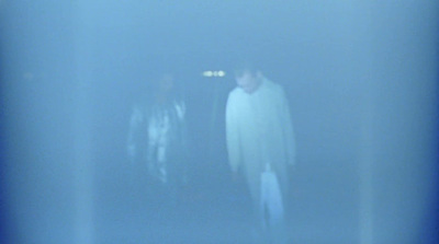 a blurry photo of two people standing in the dark