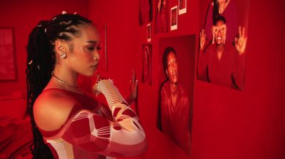 a woman standing in front of a red wall