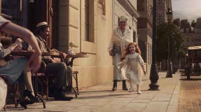 a little girl walking down a sidewalk next to a man