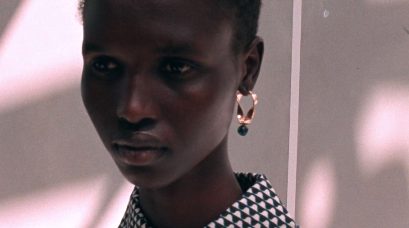 a woman in a black and white shirt and earrings