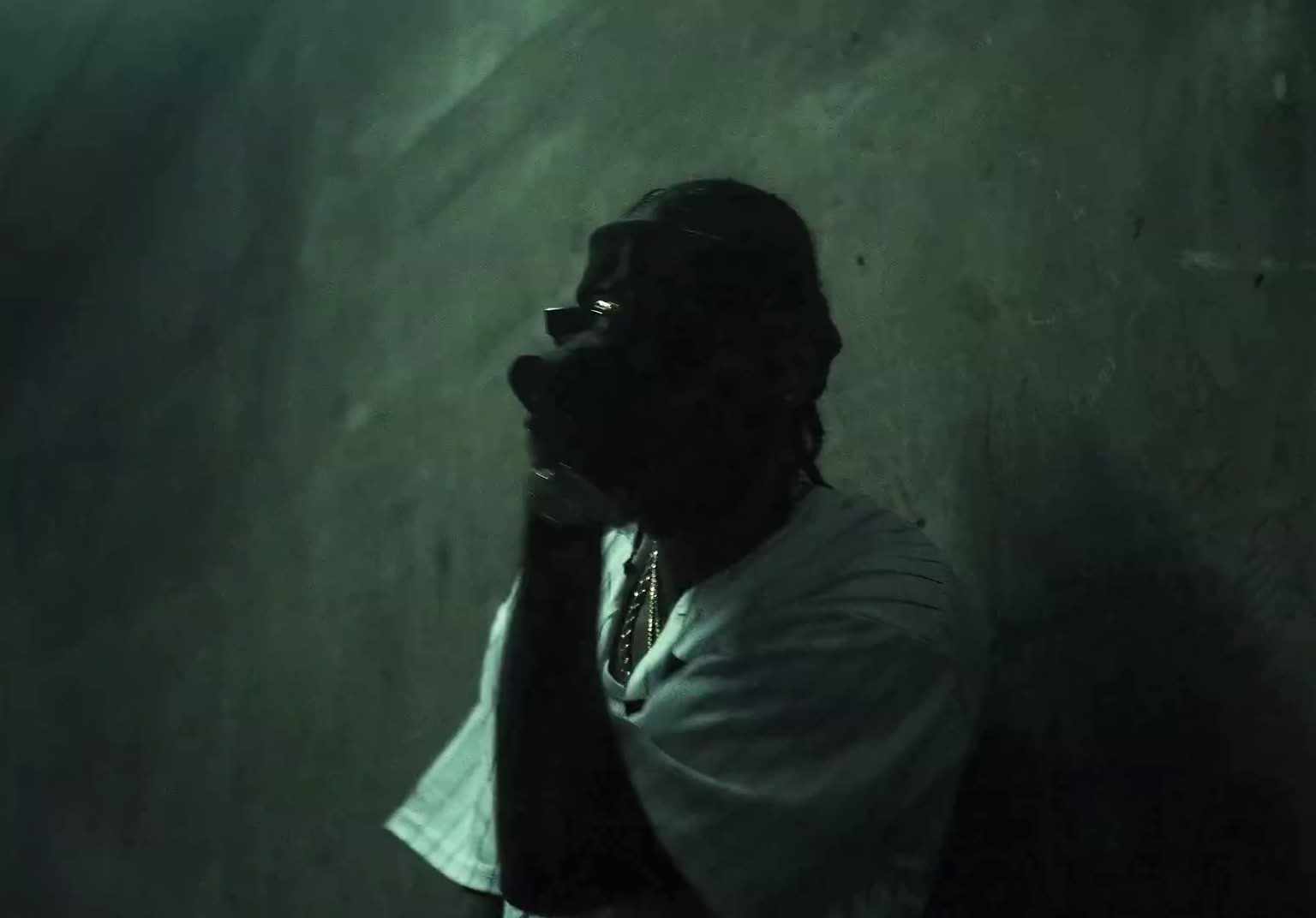 a man in a white shirt and tie standing in a dark room