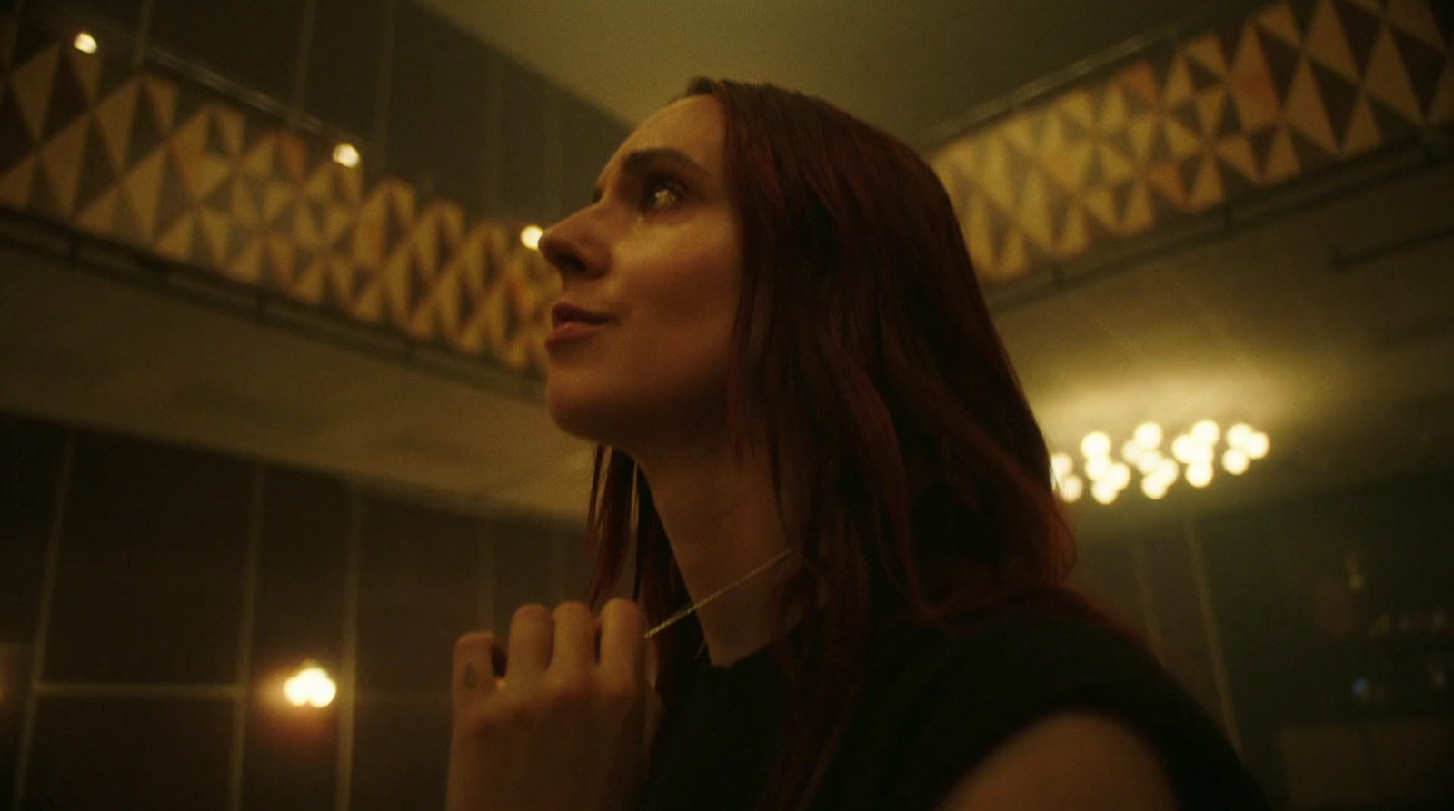 a woman standing in front of a mirror brushing her teeth