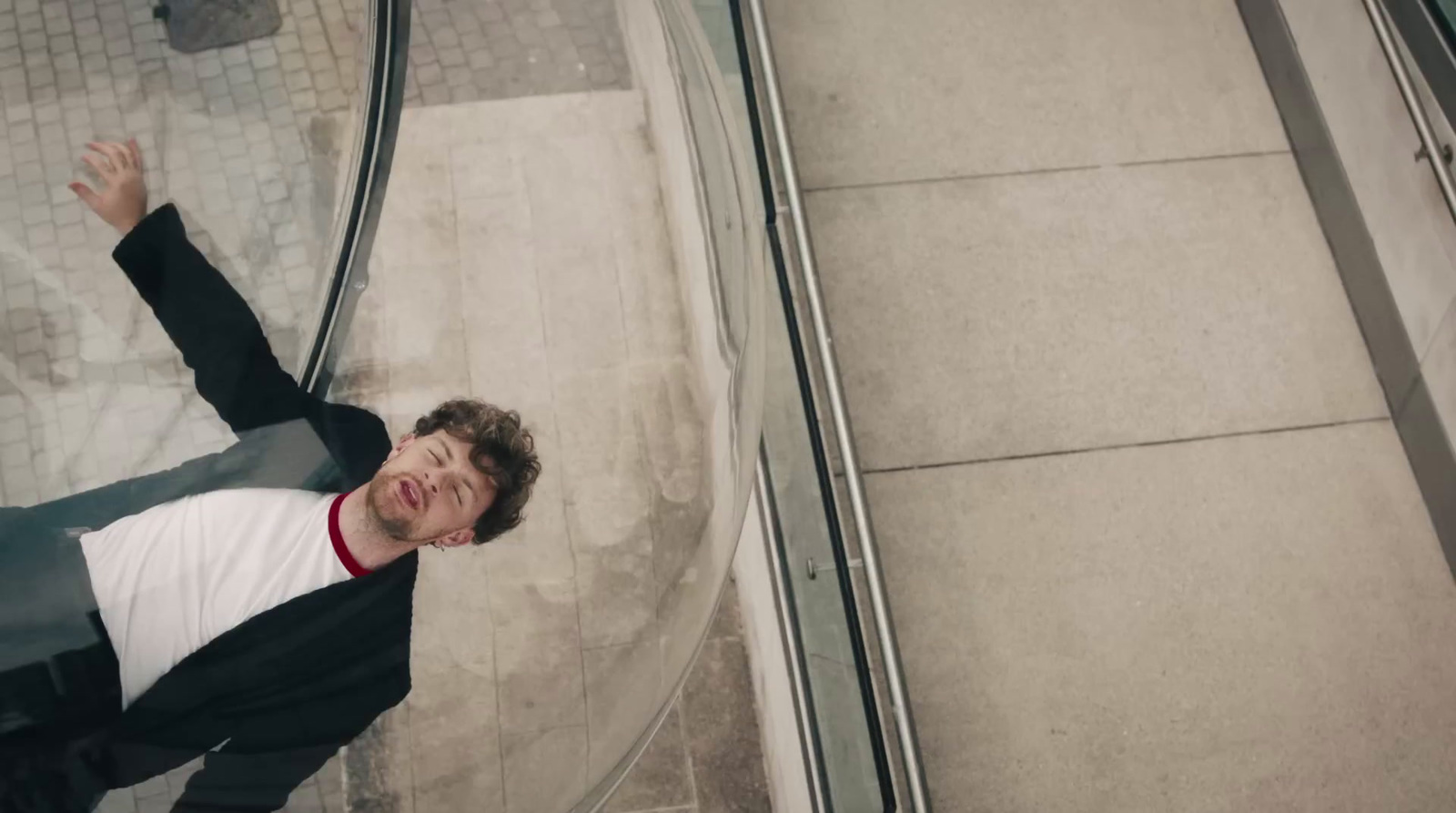 a man in a suit and tie standing next to an escalator