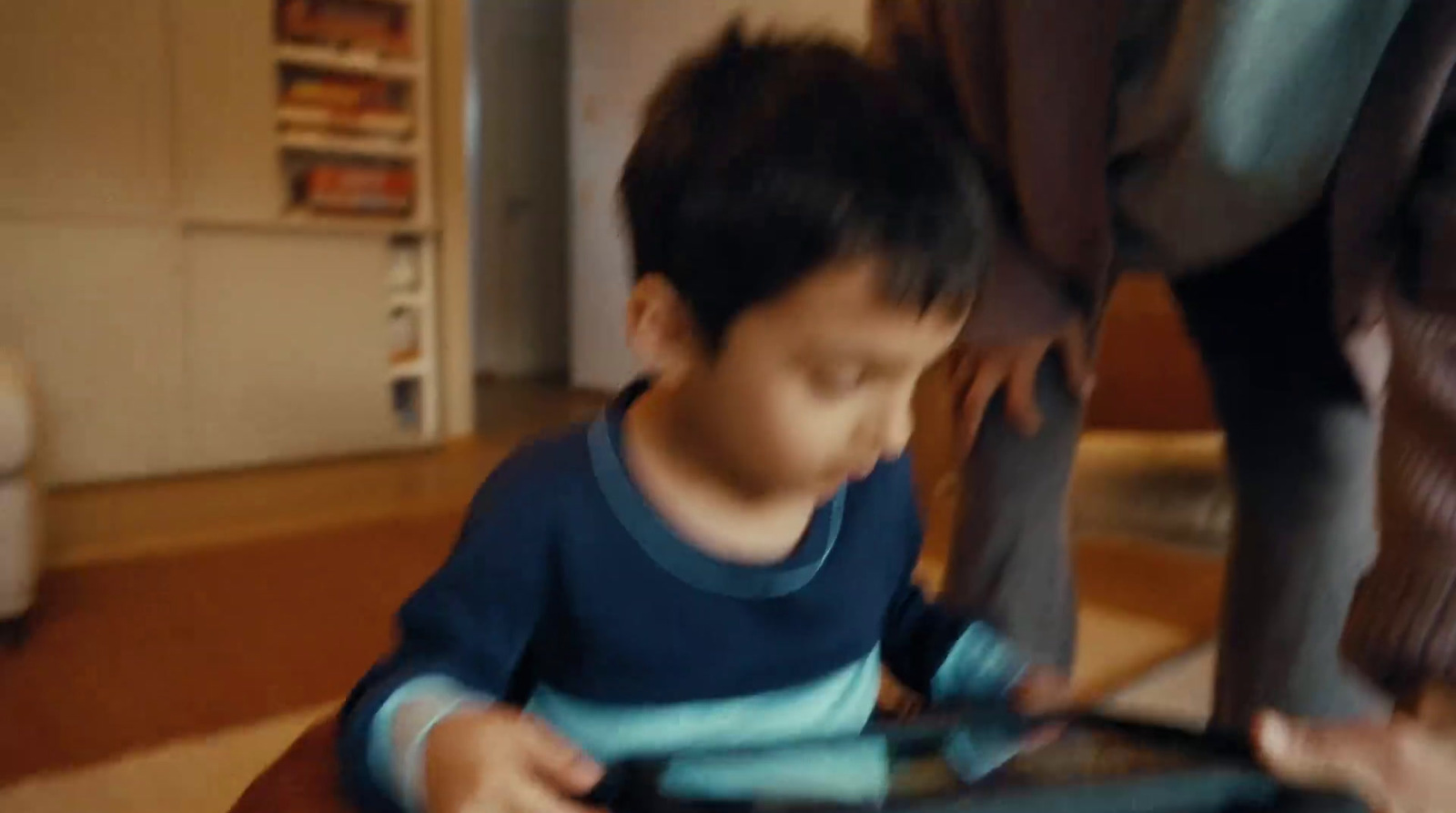 a young boy playing with a tablet computer