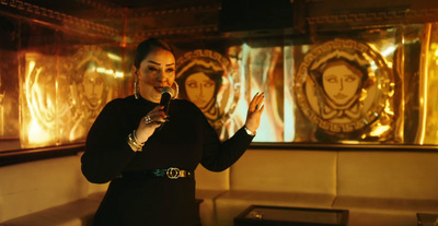 a woman standing in front of a couch holding a wine glass