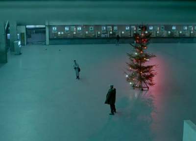 a man standing in a room next to a christmas tree