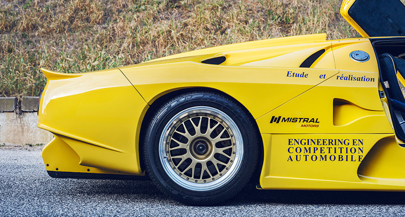 a yellow sports car parked on the side of the road