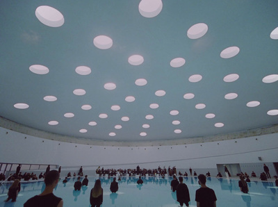 a group of people standing in a large room