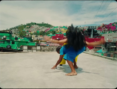 a woman in a blue dress doing a handstand on a rooftop