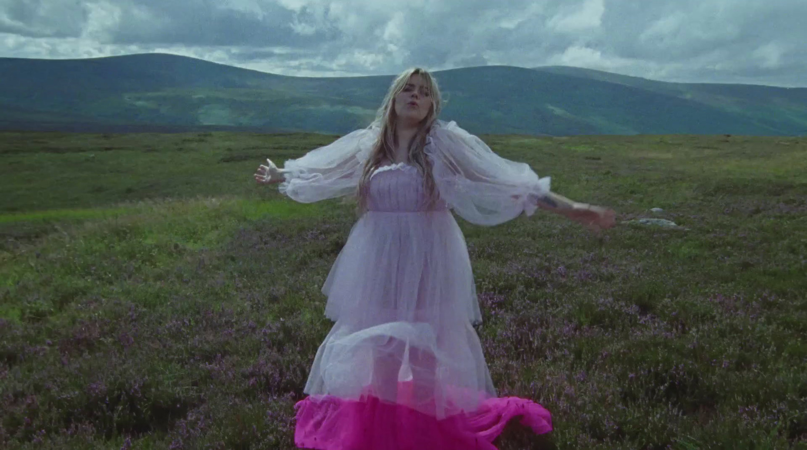 a woman in a white dress standing in a field