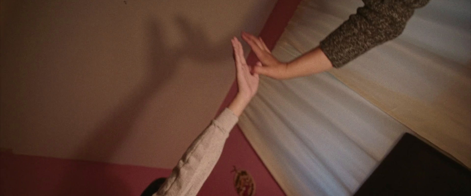 a person reaching up to grab a persons hand