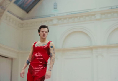 a man in a red dress standing in a room