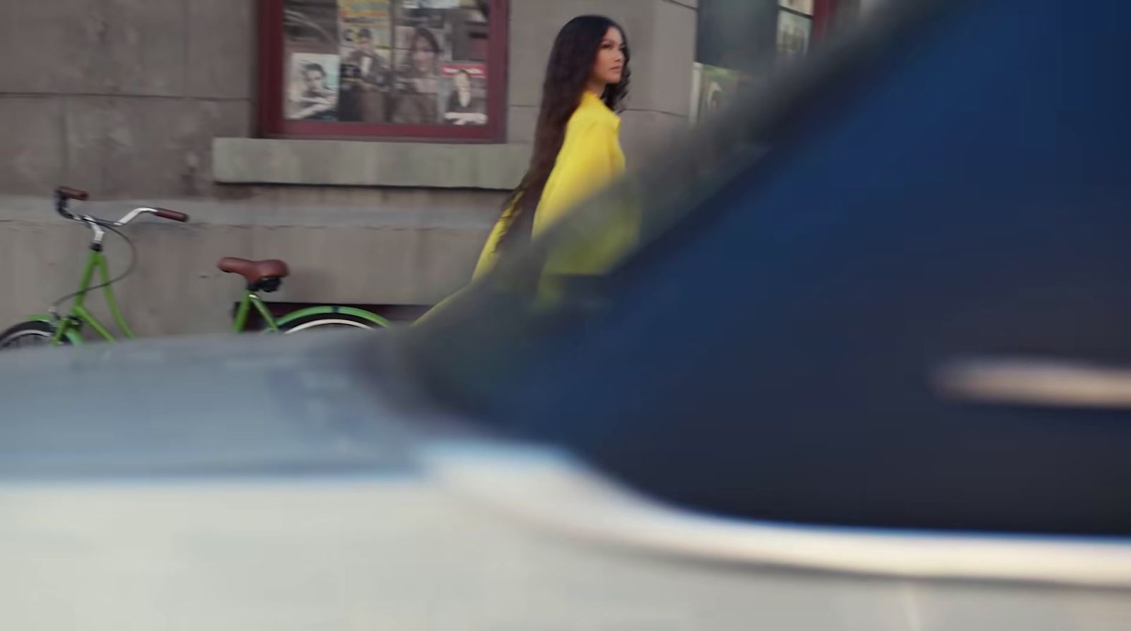 a woman in a yellow dress walking down the street