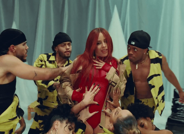 a group of people standing around a woman in a red dress