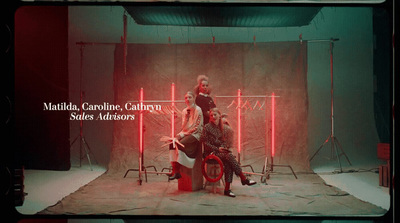 a couple of women sitting on top of a red chair